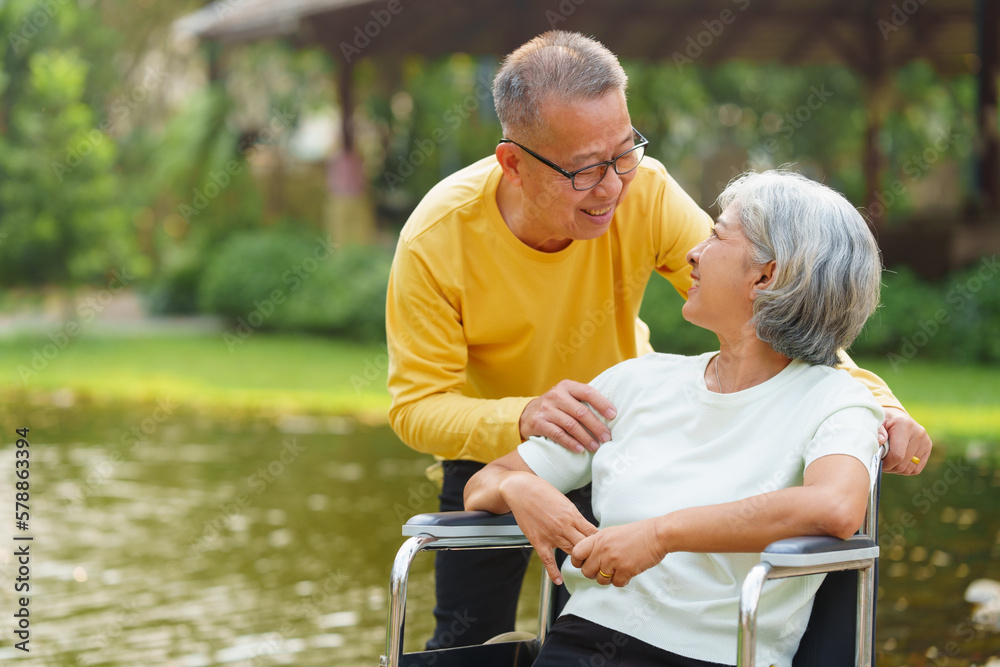 Elderly couple husband and wife happy asian people giving love and care Wheelchair in the park relaxing in spring, relaxing and walking outside at the park. Elderly couple husband and wife happy asian people giving love and care Wheelchair in the park relaxing in spring, relaxing and walking outside at the park.