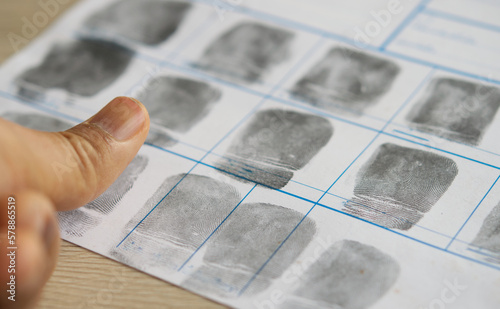 Close-up shots of criminal Taking finger to fingerprinting crime page file.Crime and violence concept..