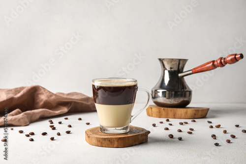 Glass cup of delicious Cafe Bombon on light table photo