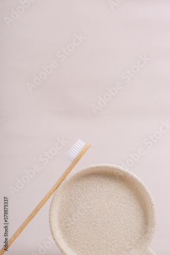 cepillo de dientes de bambú biodegradable ecologíco sobre platito de piedra en tonos neutros