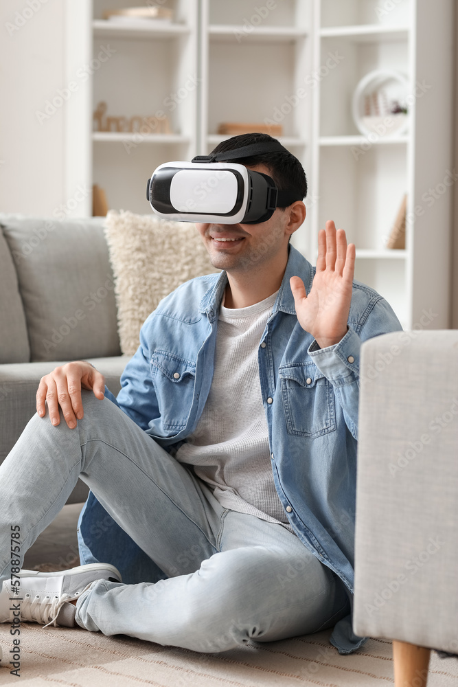 Young man using VR glasses at home Young man using VR glasses at home