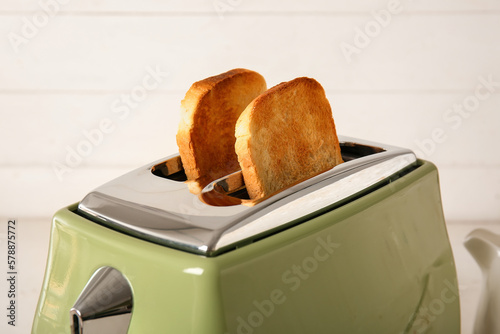 Modern toaster with crispy bread slices on white background