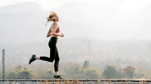 young woman runner running outdoors on the mountain.