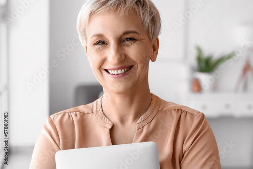 Mature woman with laptop at...