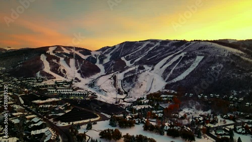 Yellow colored sky over the ski slopes of Park City in Utah. Backwards drone dolley shot during sunset photo
