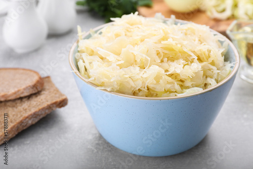 Bowl of tasty sauerkraut on grey table, closeup