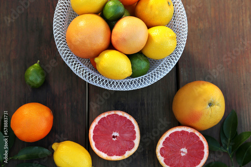 Different citrus fruits and leaves on wooden table  flat lay