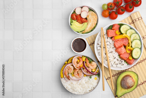 Set of delicious poke bowls with different ingredients on white table, flat lay. Space for text