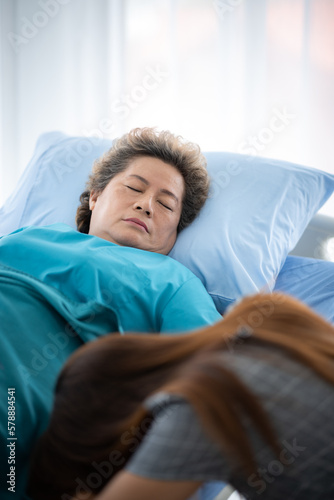 Asian senior or elderly old woman patient lie down handle the rail bed with hope on a bed in the hospital, old lady is sick and lying on the patient bed, recovering on saline drip solution © chokniti