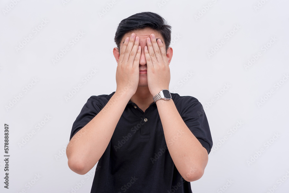 A man covers his eyes, refusing to look. Isolated on a white background. See no evil or concept of scandal. A man covers his eyes, refusing to look. Isolated on a white background. See no evil or concept of scandal.