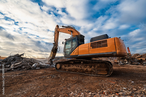 Excavator with hydraulic press breaks concrete leftovers