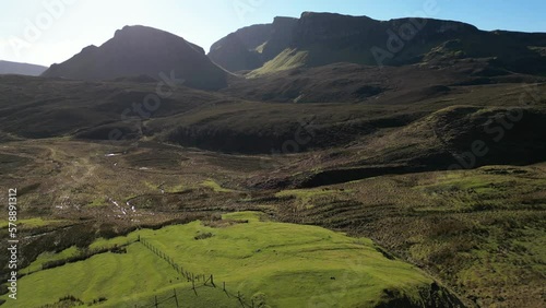 Flying slow over lush moorland towards Quiraing rock formations at the Trotternish Ridge Isle of Skye Scotland photo