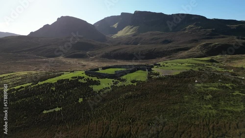 Flying slow over sheep pen and towards Quiraing rock formations at the Trotternish Ridge Isle of Skye Scotland photo