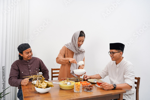 Asian Muslim families have an Iftar dinner. Eating traditional Indonesian food during Ramadan feasting month at home. 