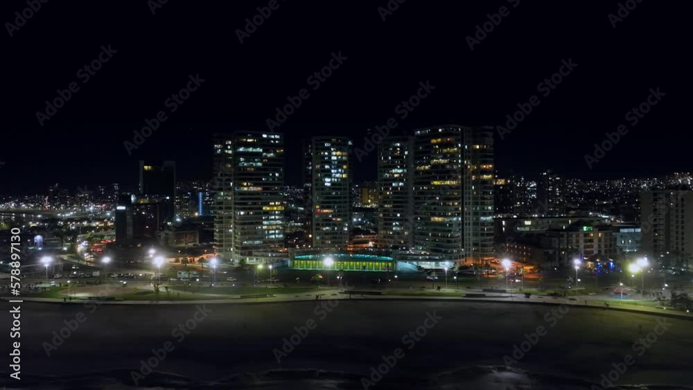 Aerial dolly left shot of bright lights on in the beachfront skyscrapers in Iquique, Chile Aerial dolly left shot of bright lights on in the beachfront skyscrapers in Iquique, Chile