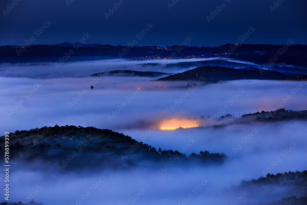 Fototapeta premium The warm lights from the greenhouse to grow flowers in the dawn at Da Lat town. Da Lat always is foggy town in the morning. Dalat is one of the most tourist beautiful and the famous town in Viet Nam.