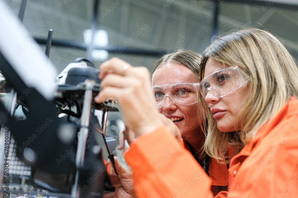 Multiracial tachnicial engineer training with robot arm Multiracial tachnicial engineer training with robot arm