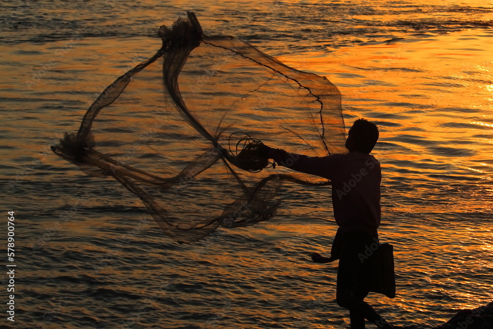 cast net fishing on the river ganges during sunset, rural lifestyle of  india Stock Photo