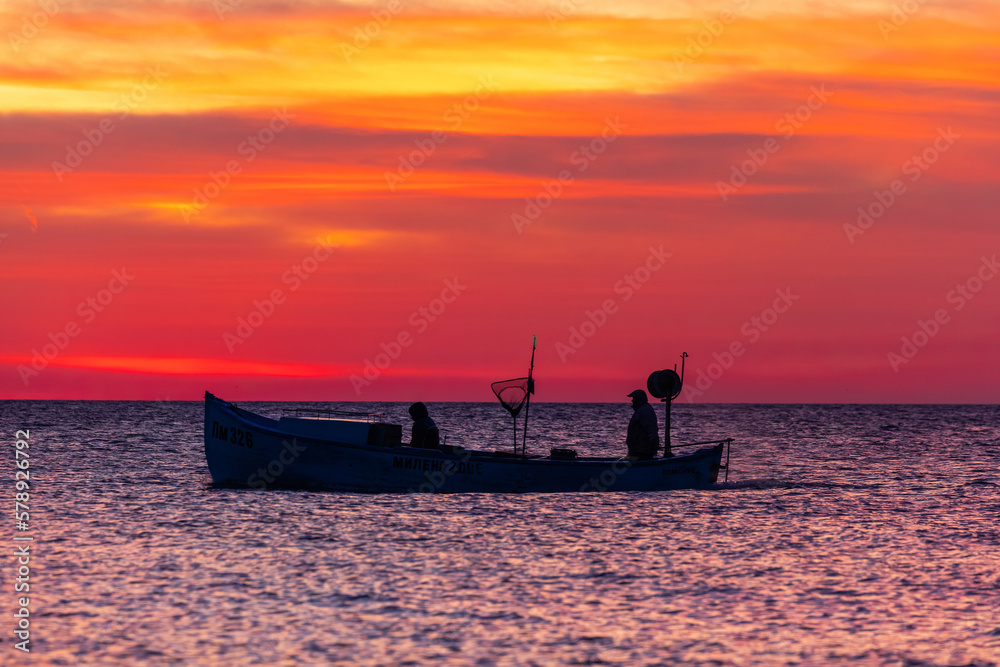 Boat and sea sunrise, beautiful cloudscape and fisherman silhouette