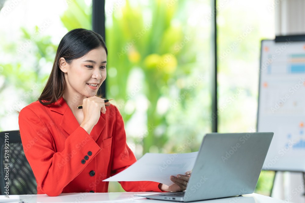 Portrait of pretty cheerful girl smiling while working on laptop in office Portrait of pretty cheerful girl smiling while working on laptop in office