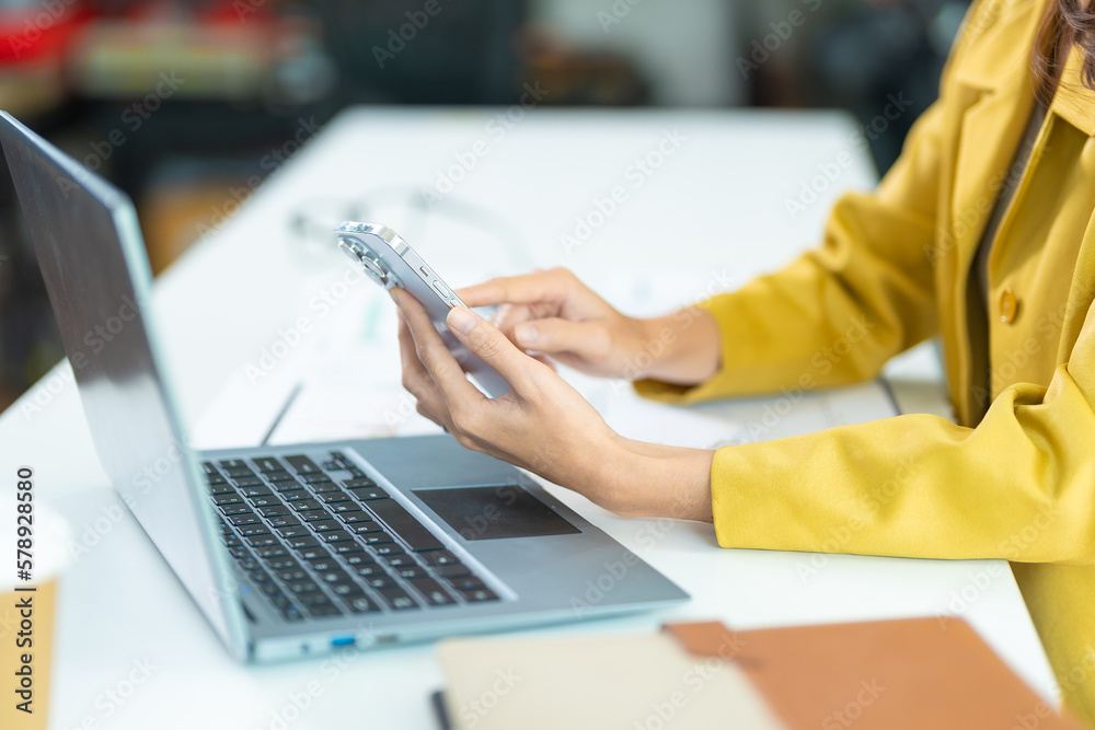 Young business woman on the phone at the office.Business woman texting on the phone and working on laptop.Beautiful young business woman sitting in office.Business woman smiling. Young business woman on the phone at the office.Business woman texting on the phone and working on laptop.Beautiful young business woman sitting in office.Business woman smiling.