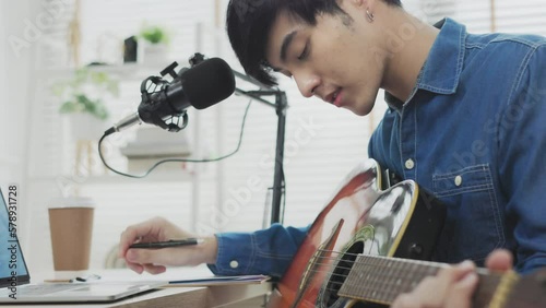 Wallpaper Mural Young asian man playing guitar on laptop computer  recording video content for online lesson. tutorial vlog training filming video course for social media at home. Torontodigital.ca