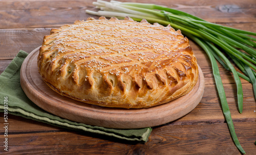 savory pie with a filling on a wooden background
