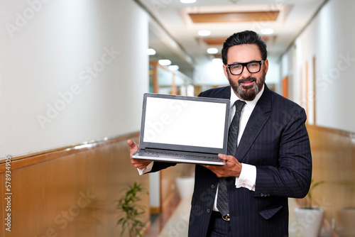 Indian businessman showing laptop screen