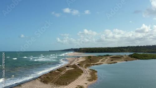 Descending aerial drone shot of the beautiful coastline of Gramame where the ocean meets the river near the tropical beach capital city of Joao Pessoa in Paraiba, Brazil on a warm summer day. photo