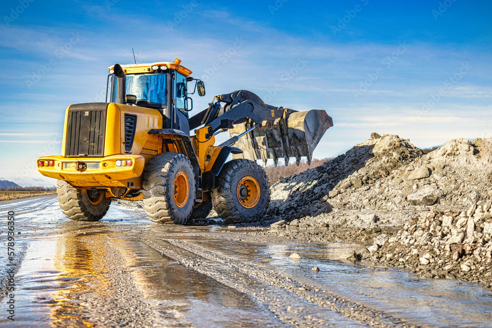 Powerful wheel loader or bulldozer working on a quarry or construction site. Earthworks in construction. Powerful modern equipment for earthworks. Powerful wheel loader or bulldozer working on a quarry or construction site. Earthworks in construction. Powerful modern equipment for earthworks.