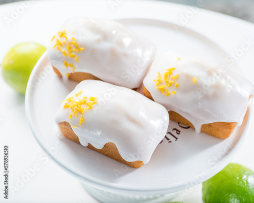 Schilderij op canvas Rectangular muffins covered with white cream glaze and sprinkled with lime zest