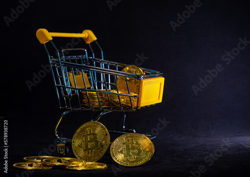 Yellow trolley full of golden bitcoin with black background, Digital business and finance concept, Focus on groub of bitcoin in front photo