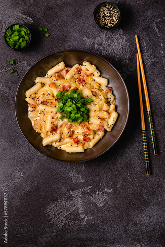 Spicy Rice Cake with Cheese and Bacon or Cream Teokbokki, Tteokbokki. photo