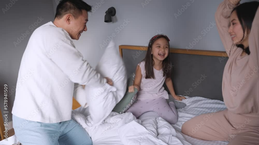 Funny Asian family hits with pillows in the bed at home Funny Asian family hits with pillows in the bed at home