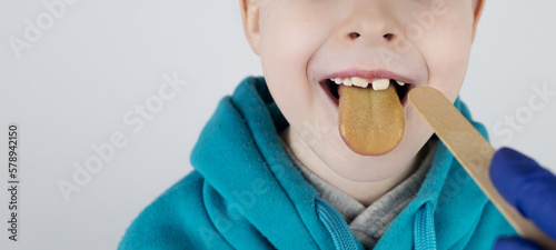 Konstfotografi Blond boy has a yellow tongue