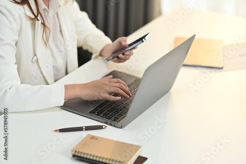 Young woman financial advisor communicating with client via laptop computer at her workstation