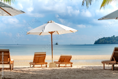 The sun loungers under umbrellas on the sandy beach on paradise island Villa Koh Rong Samloem. Cambodia. This is a small island that