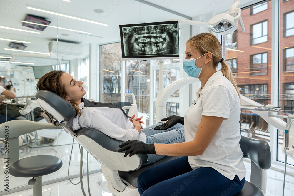 Dentist and patient choose treatment during consultation with medical equipment in dentistry. Dentist and patient choose treatment during consultation with medical equipment in dentistry.