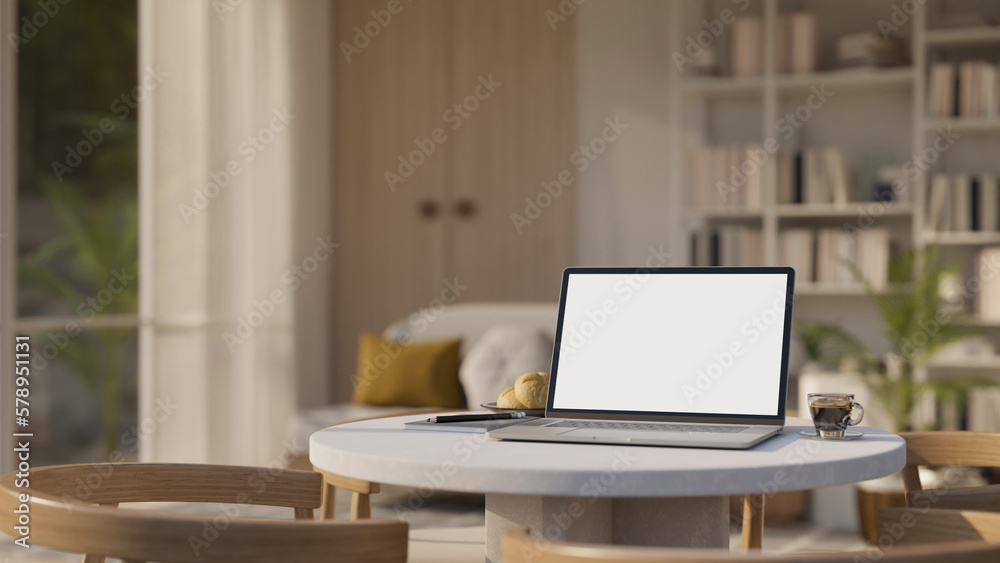 Laptop mockup and decor on table in cozy contemporary living room, home workspace