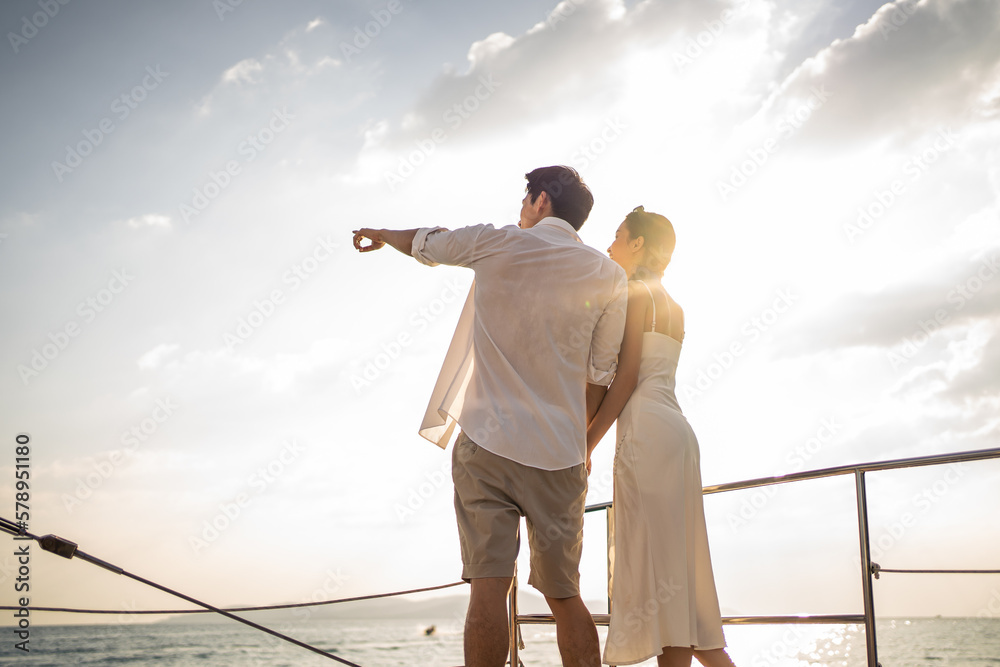 Asian young romantic couple looking at beautiful view during yachting.  - obrazy, fototapety, plakaty 