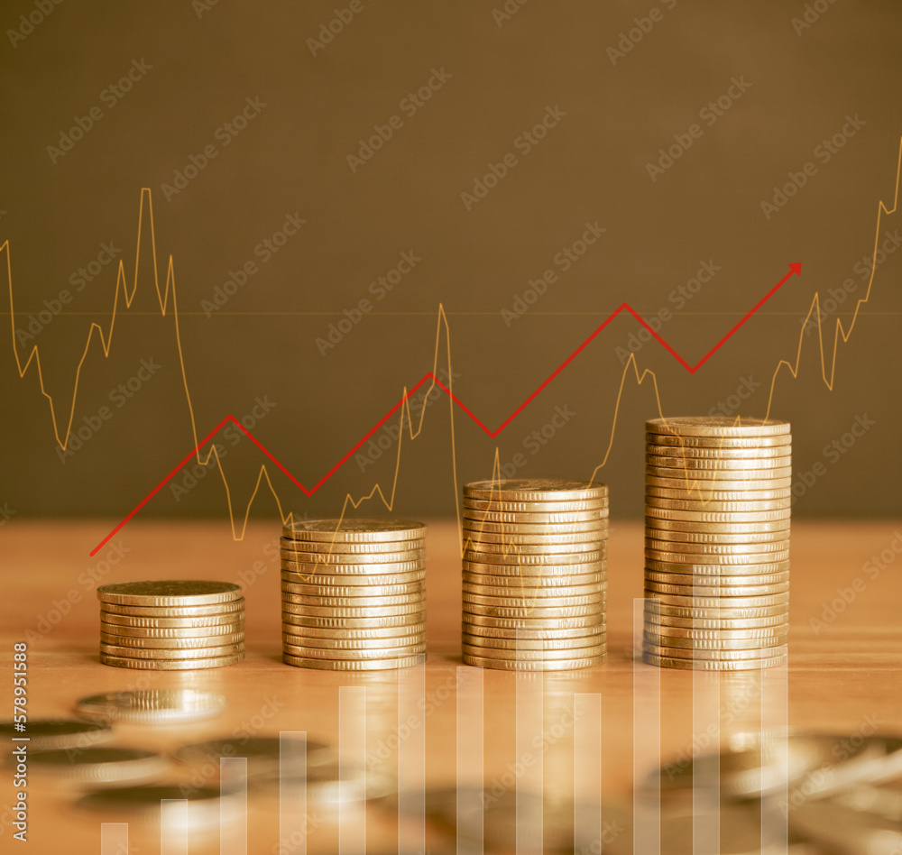 Stack of golden money coin on wood desk with graph and red up arrow Stack of golden money coin on wood desk with graph and red up arrow