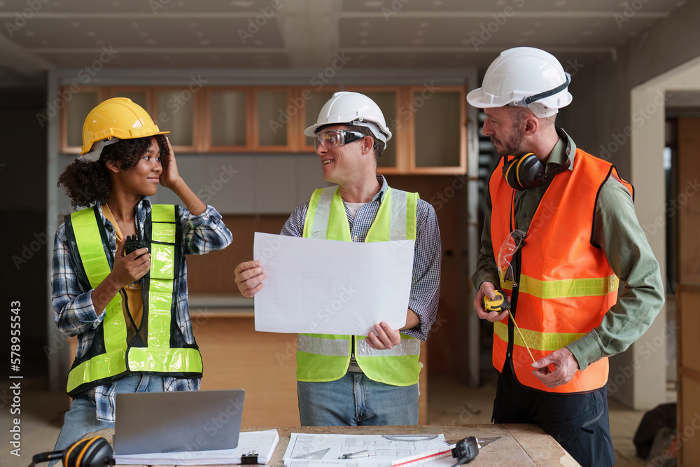 Architect team working with blueprints for architectural plan, engineer sketching a construction project, green energy concept Architect team working with blueprints for architectural plan, engineer sketching a construction project, green energy concept