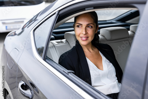 A beautiful business woman is driving in the car
