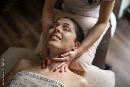 A beautiful young woman is enjoying a massage in a SPA centre