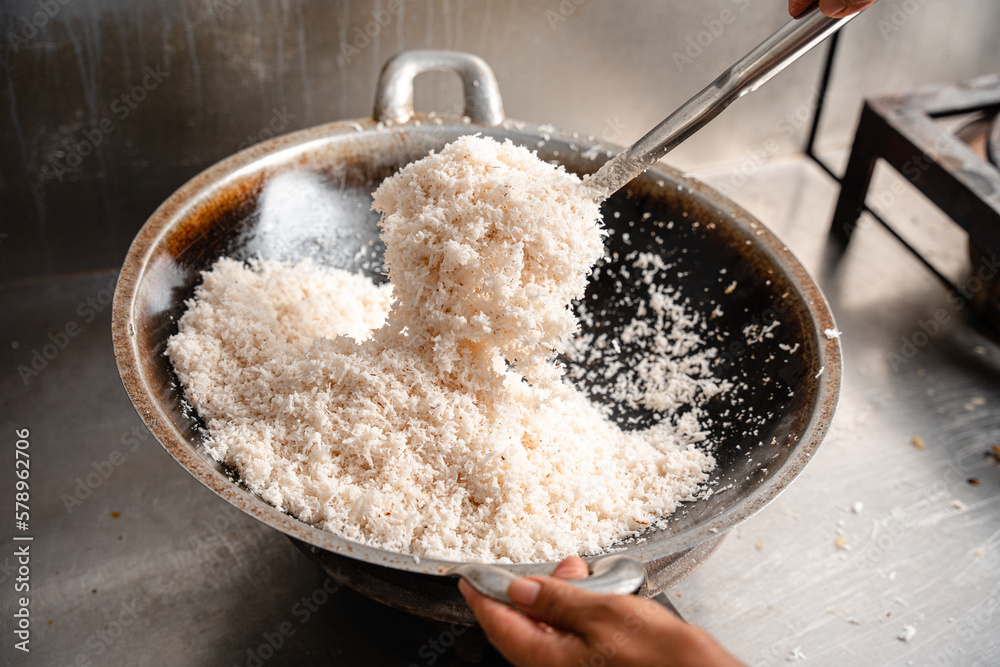 the process of making Serundeng. Serundeng is made from grated coconut which is fried until golden brown