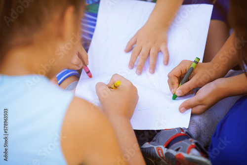 Children drawing on a paper together
