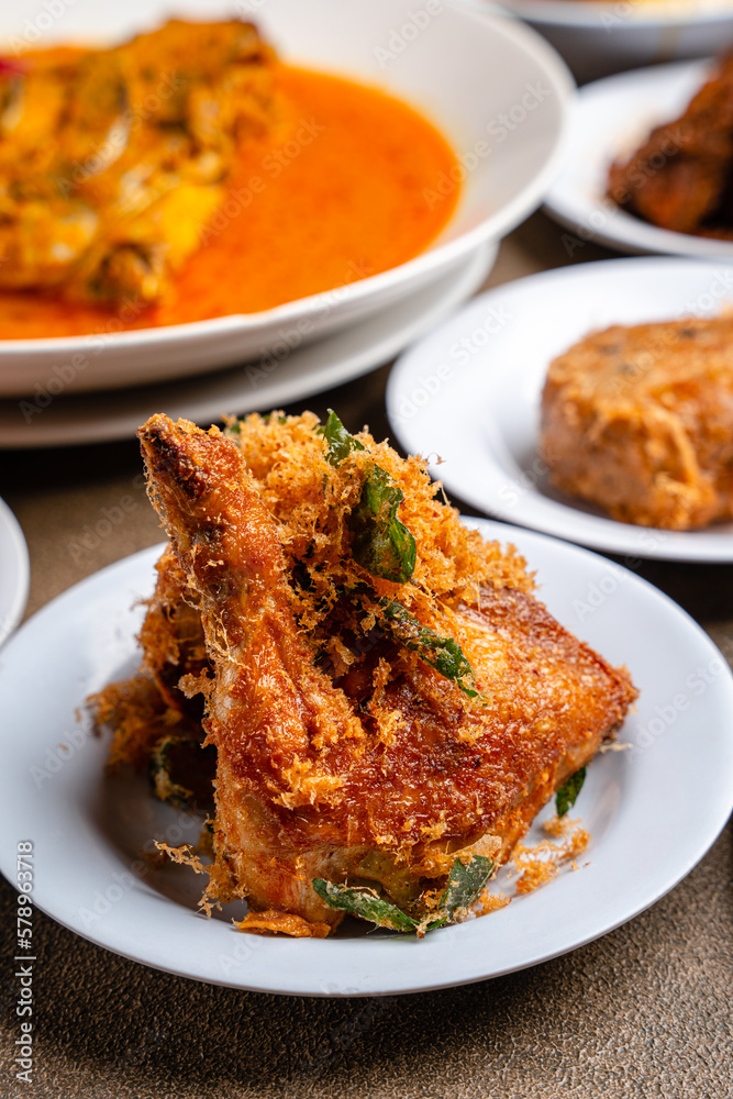Ayam Goreng Padang. Traditional fried chicken with spice crumbs from Minangkabau, West Sumatra. served on white plate 