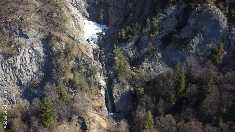 Aerial approach of a mountains waterfall with snow on top Aerial approach of a mountains waterfall with snow on top