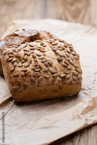 Gold rustic crusty loaves of bread and buns on wooden background. Still life captured from above top view, flat lay.