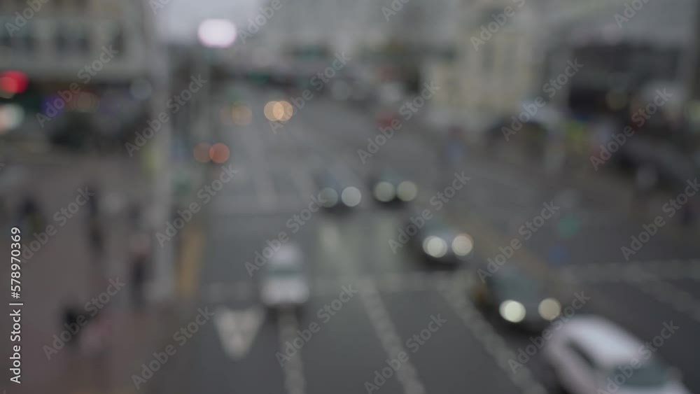 Transportation movement is blurry on city road view from above. Defocused cars and walking people is cityscape top view. Transportation movement is blurry on city road view from above. Defocused cars and walking people is cityscape top view.